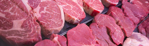 Raw beef steaks with marbling on a metal tray